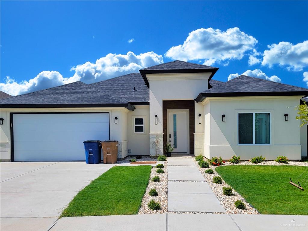 View of front of home with a front yard and a garage