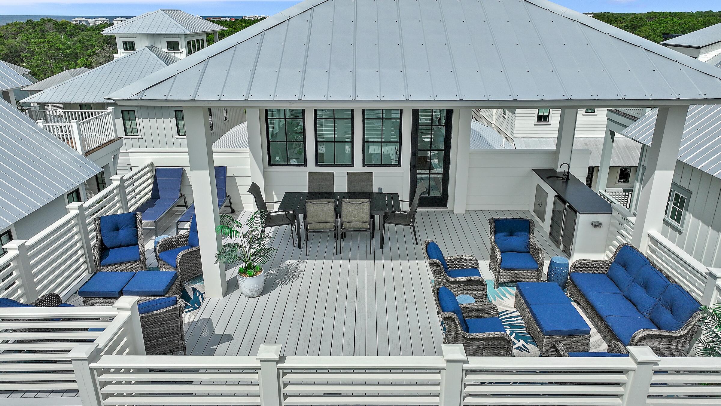 a view of a patio with table and chairs with wooden floor and fence