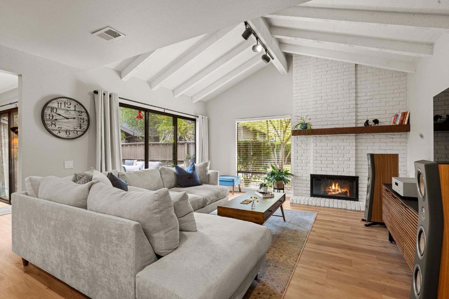 a living room with furniture a fireplace and a large window