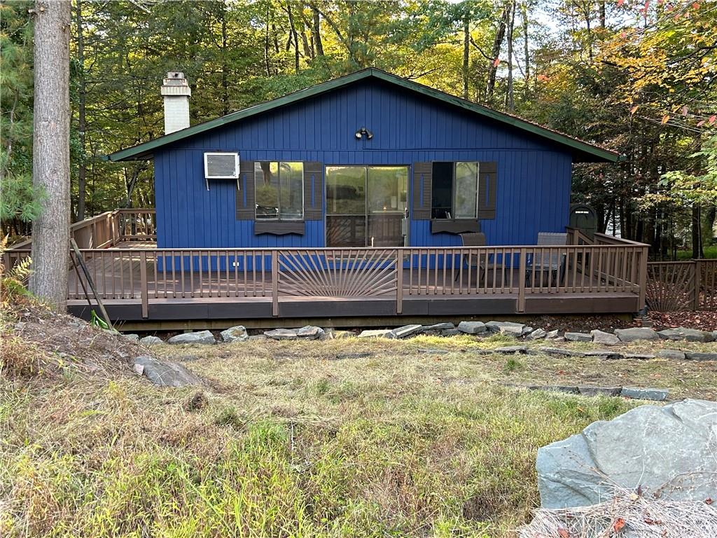 Back of house featuring an AC wall unit and a deck