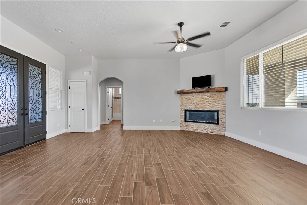 wooden floor fireplace and windows in an empty room