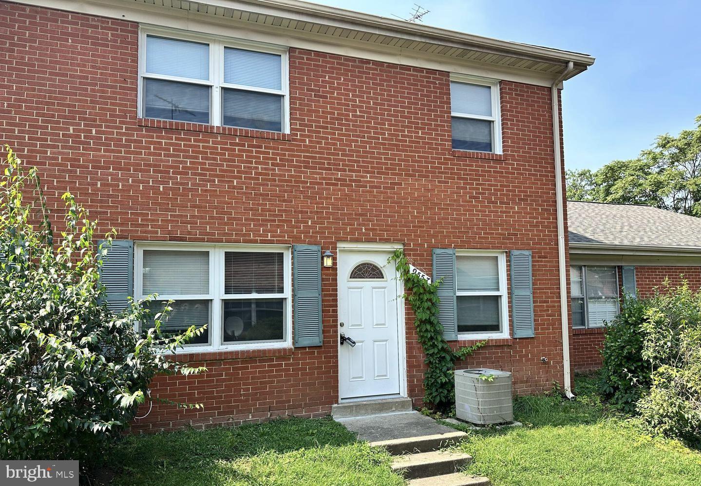 front view of a brick house with a yard