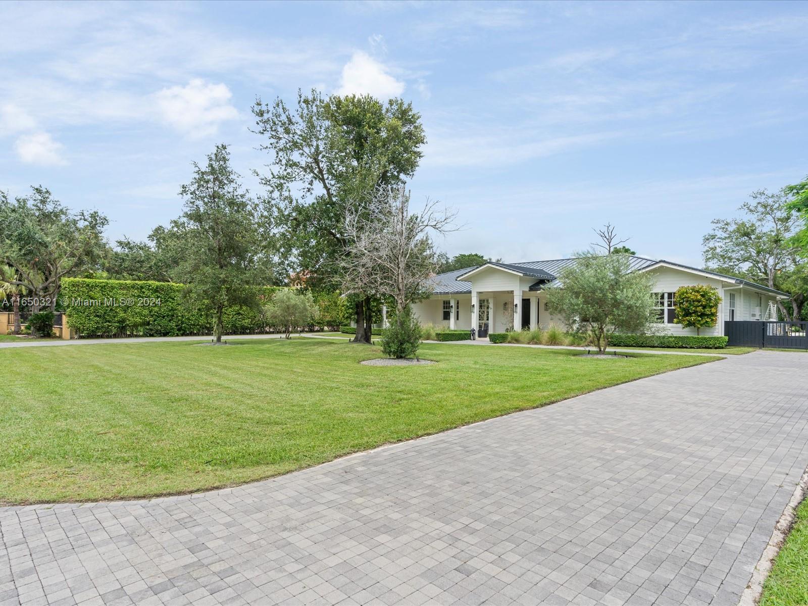 a view of a house with a big yard and potted plants