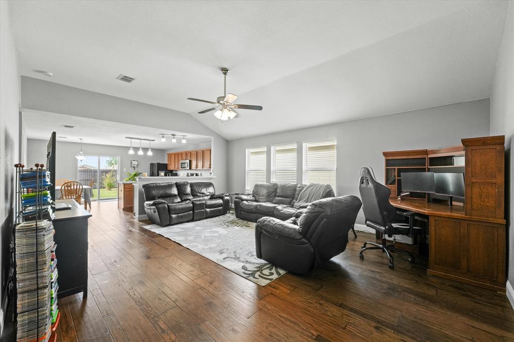 a living room with furniture flat screen tv and wooden floor