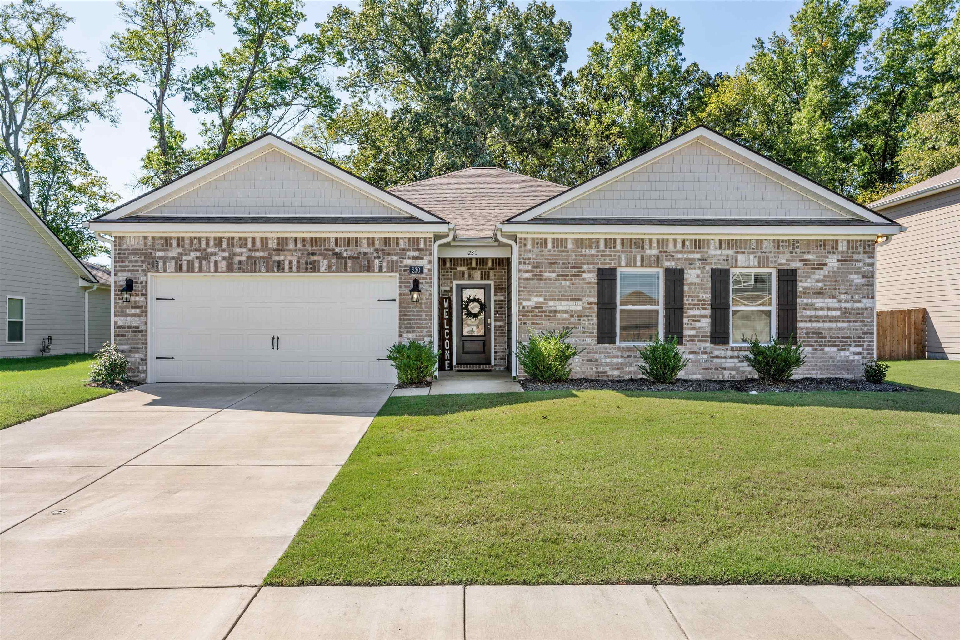 View of front of home featuring a front lawn and a garage