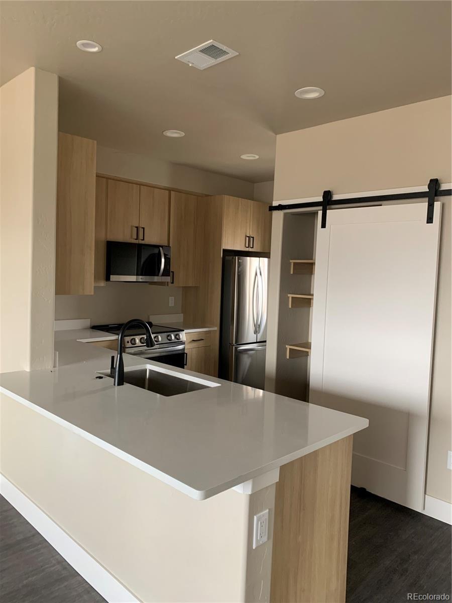 a kitchen with kitchen island a refrigerator sink and stove