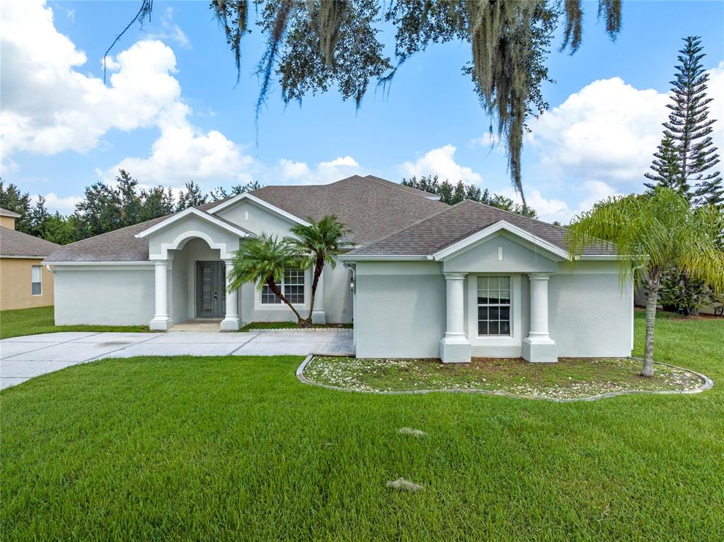 a front view of house with yard and green space