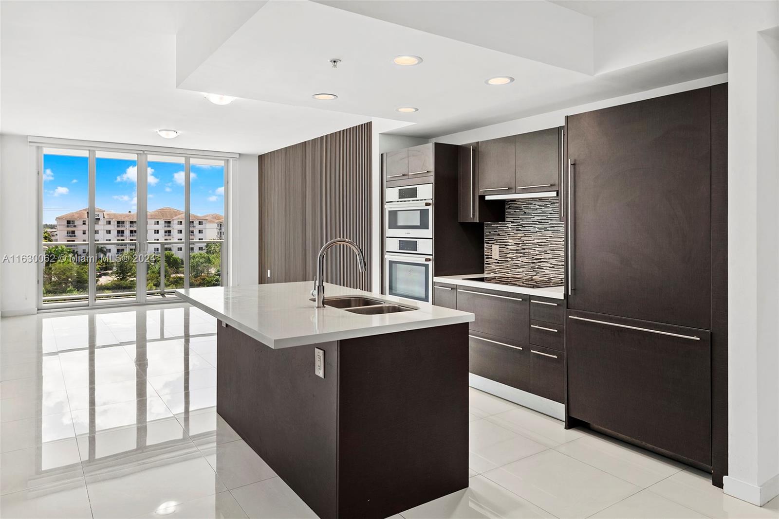 a kitchen with stainless steel appliances granite countertop a refrigerator and a sink