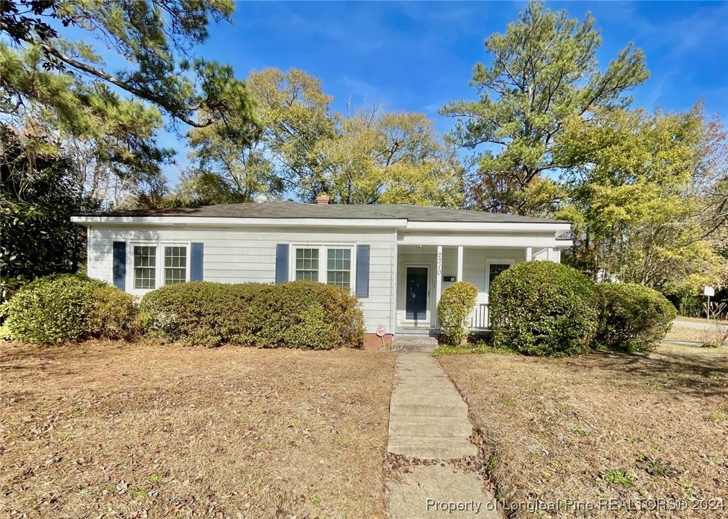 a front view of house with yard and trees around