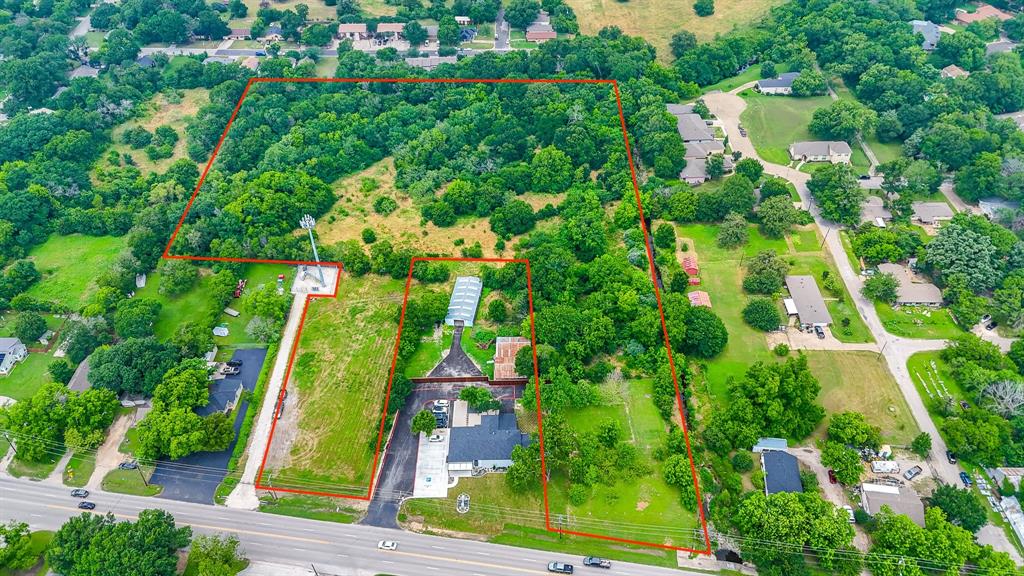 an aerial view of a residential houses with yard and green space