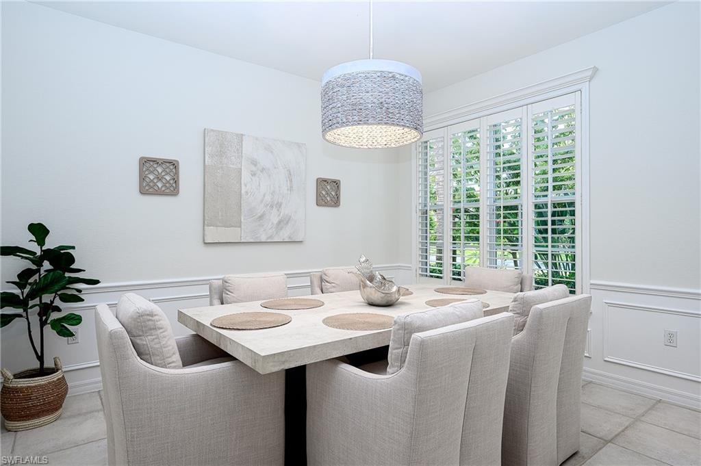 Dining space with light tile patterned floors and a chandelier