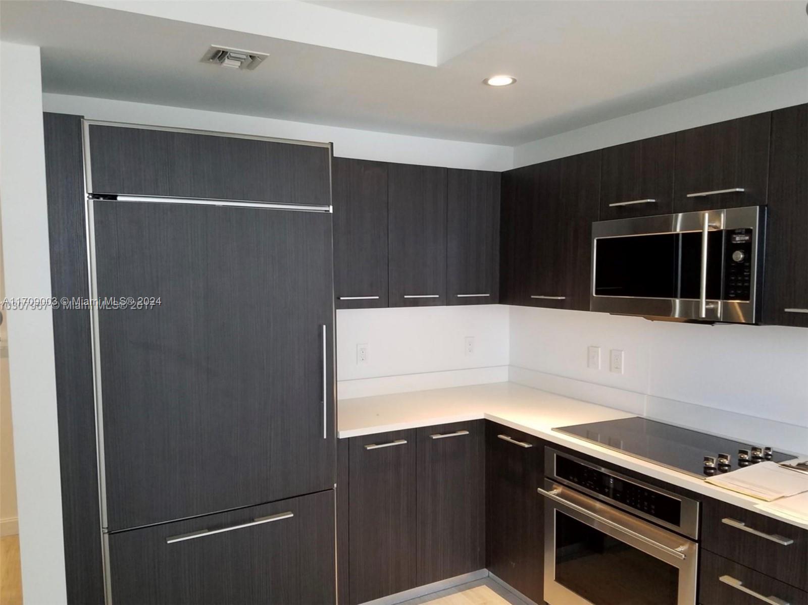 a kitchen with a refrigerator and a stove