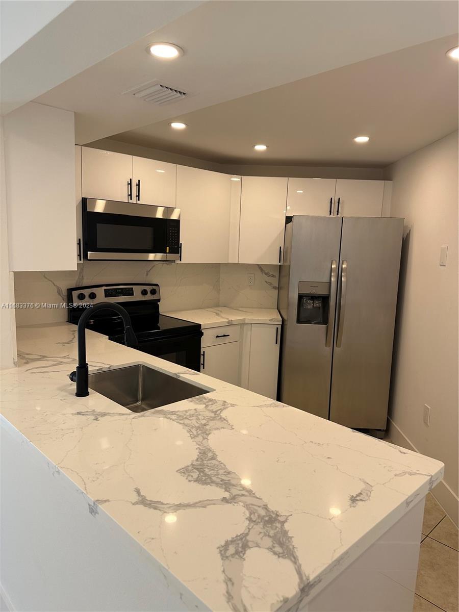 a kitchen with stainless steel appliances a refrigerator and a stove top oven