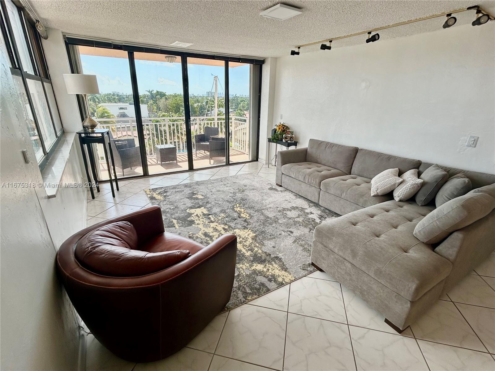 a living room with furniture and a floor to ceiling window