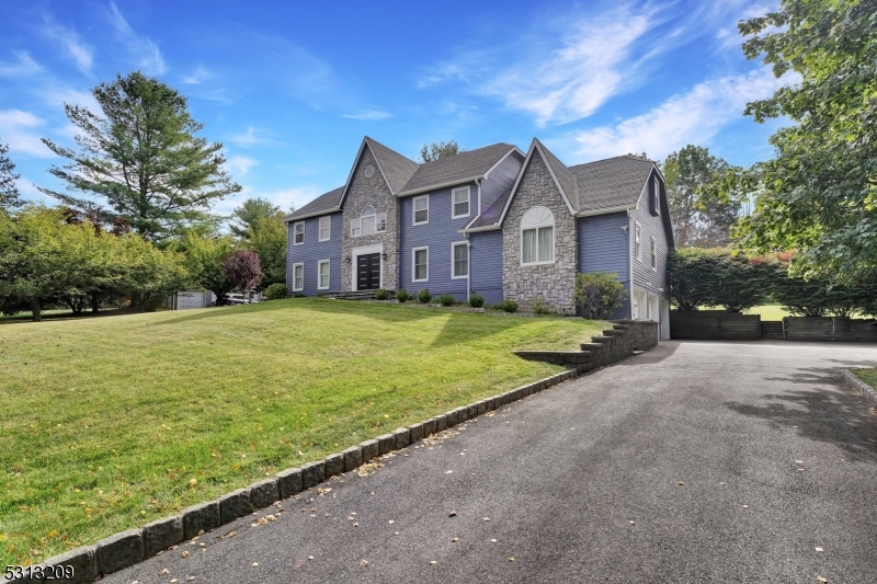 a view of a big house with a big yard and large trees