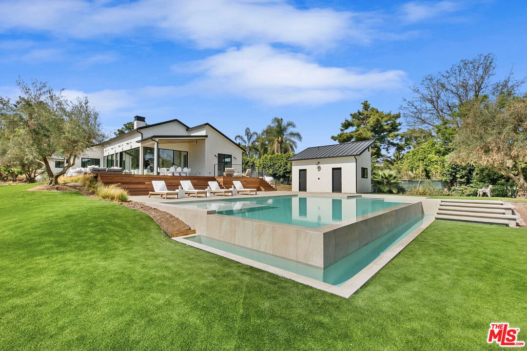 a front view of a house with swimming pool having outdoor seating