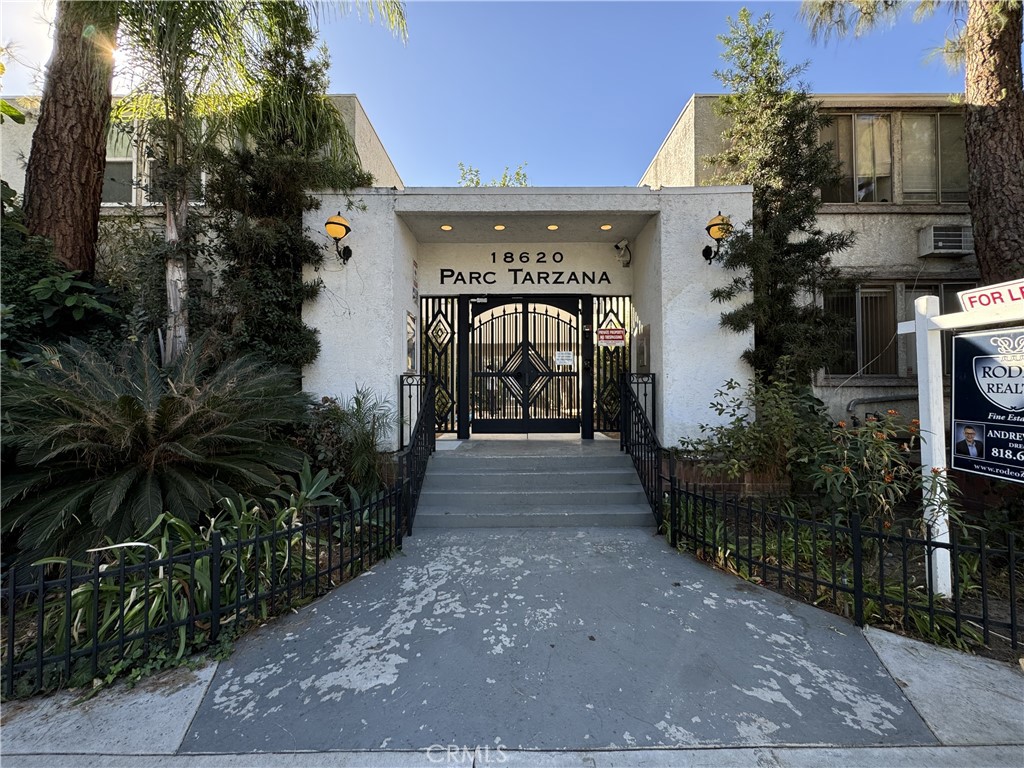 a view of a pathway of a house with potted plants