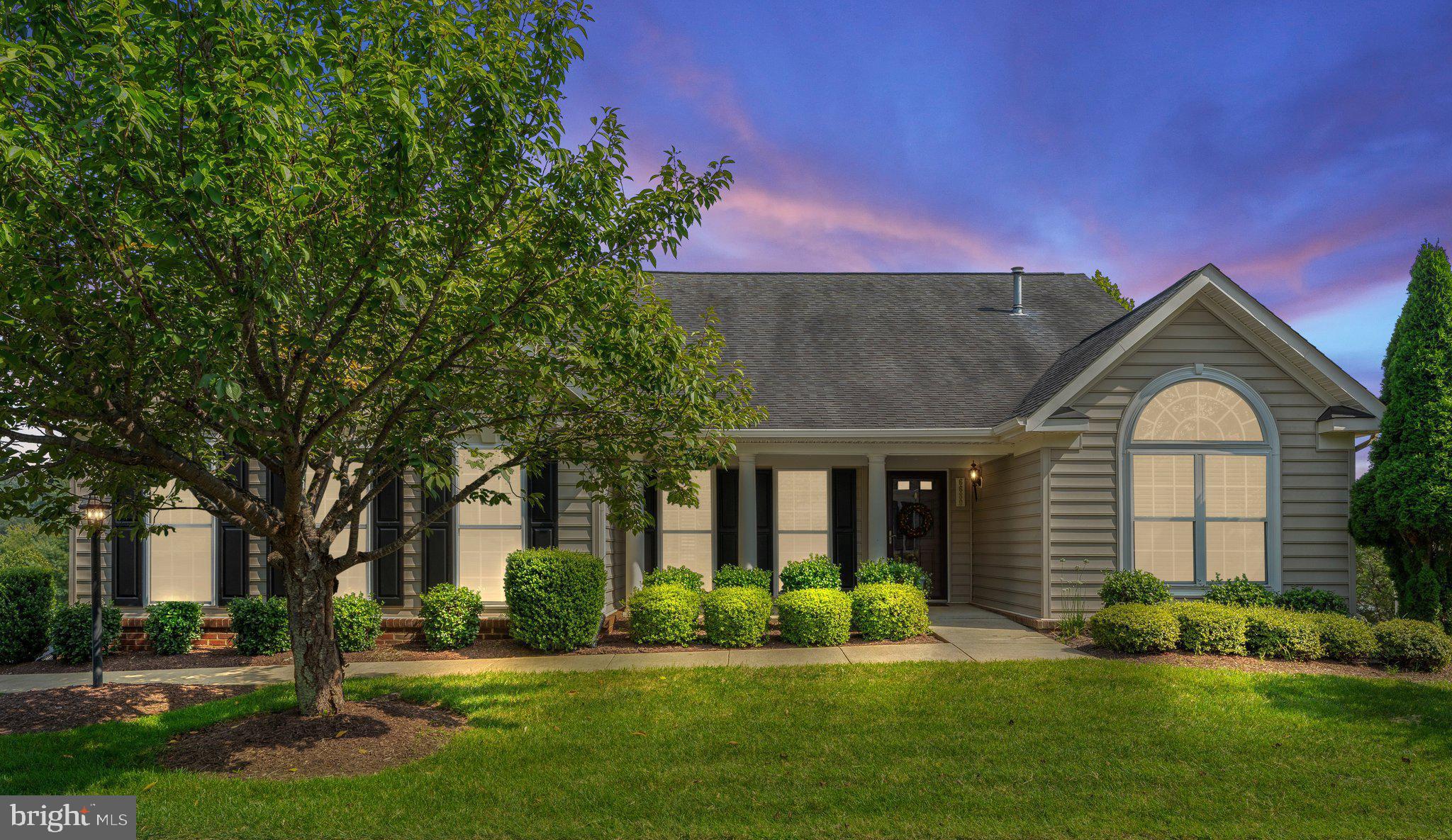 a front view of a house with a yard and trees