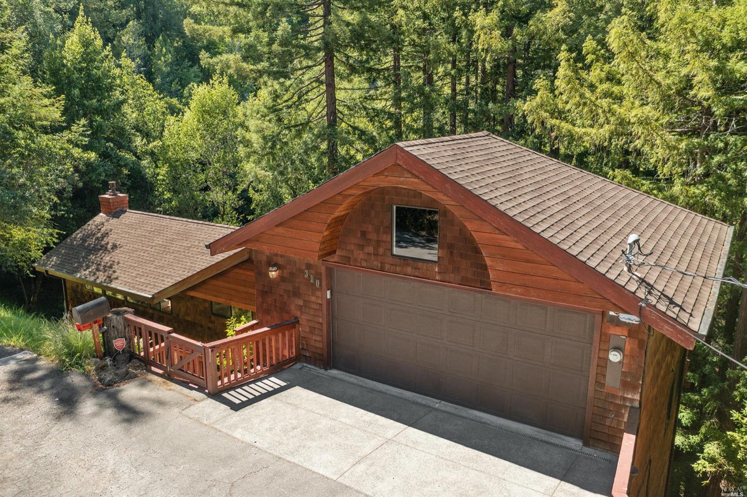 a view of a roof deck with wooden fence and large trees