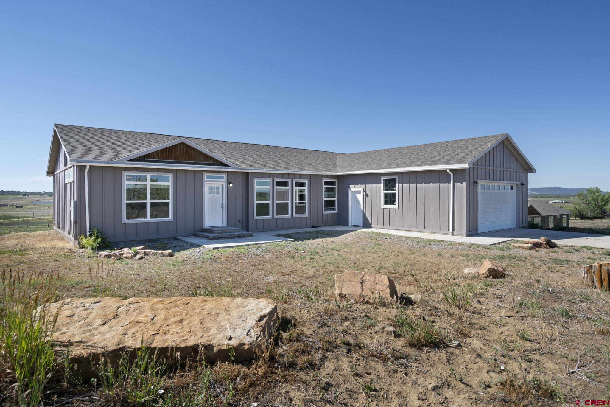 a view of a house with a yard and garage