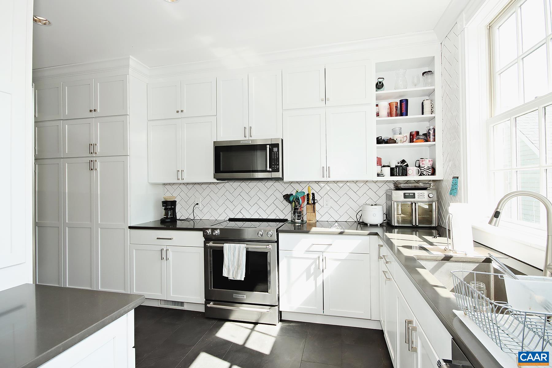 a kitchen with stainless steel appliances granite countertop a sink and a stove