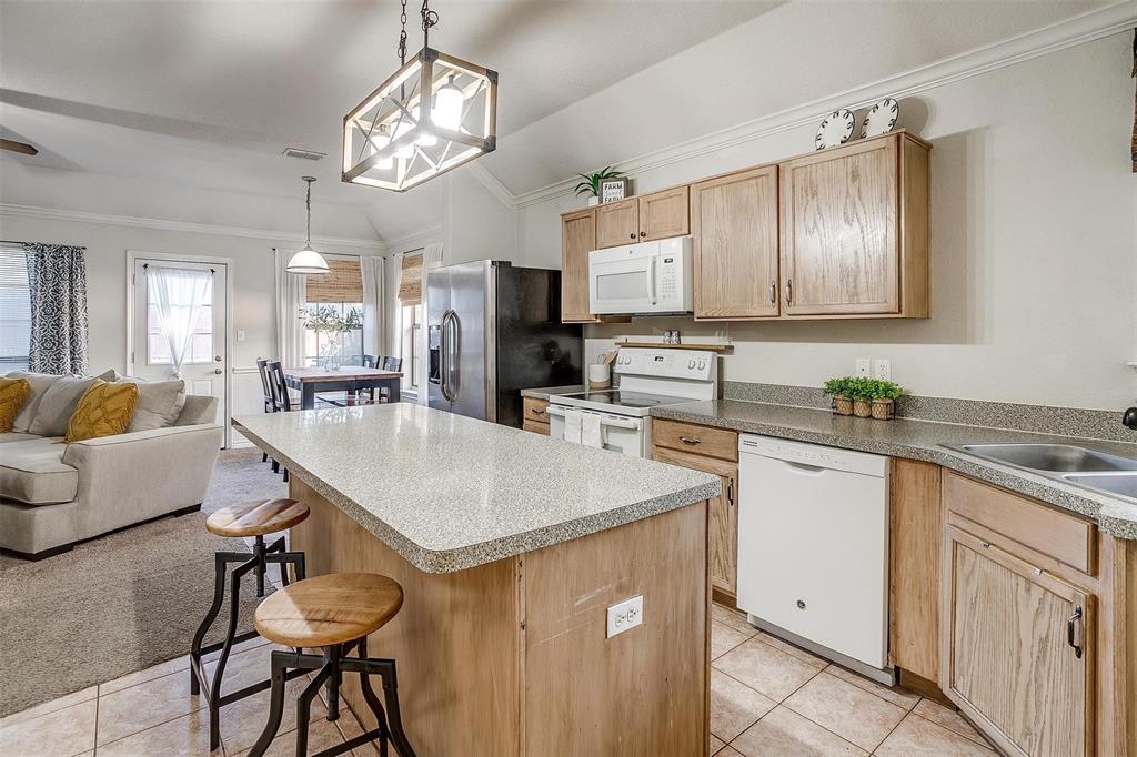 a kitchen with cabinets a sink dining table and chairs