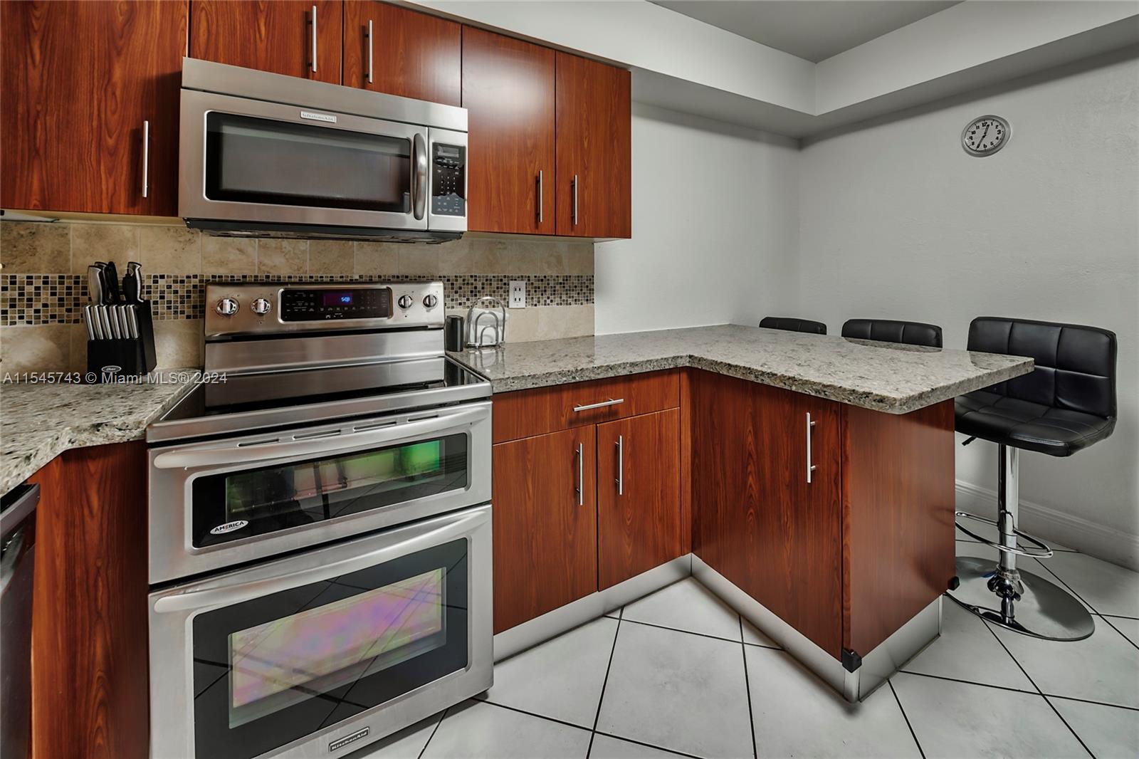 a kitchen with granite countertop a stove microwave and sink