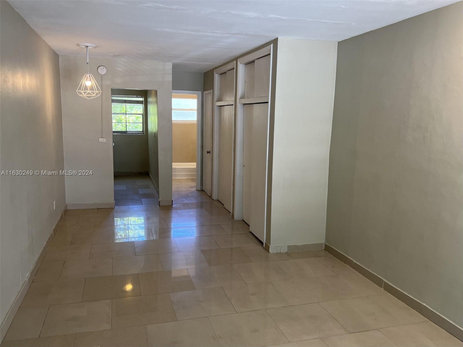 an empty room with windows and wooden floor