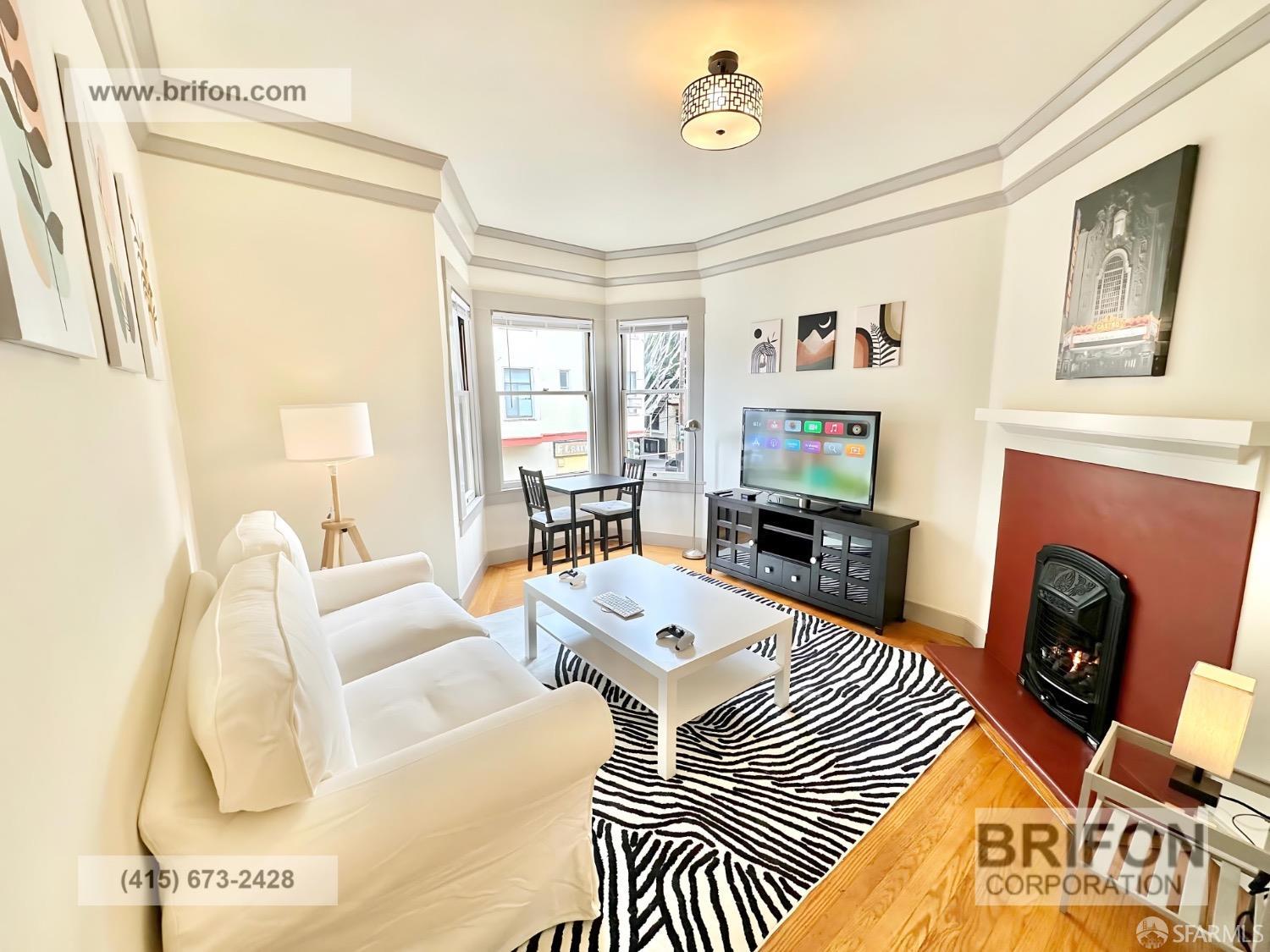 a living room with furniture a fireplace and a table