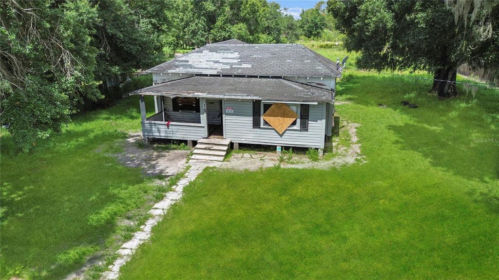 a aerial view of a house with a yard table and chairs