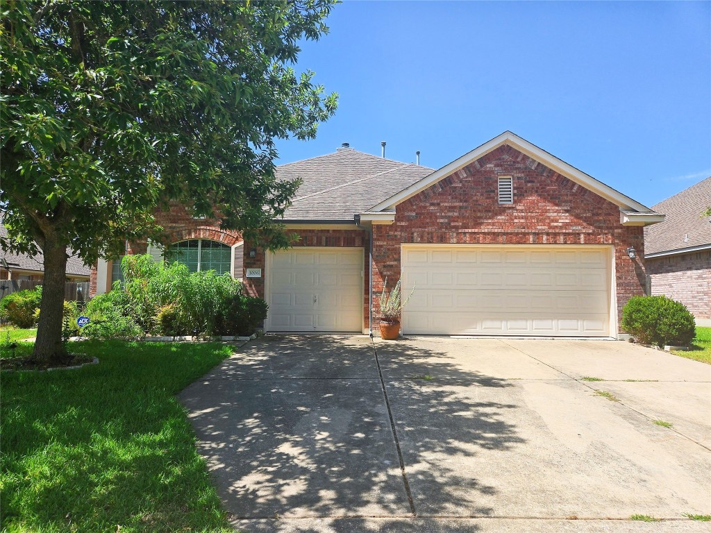 a front view of a house with a garden and yard