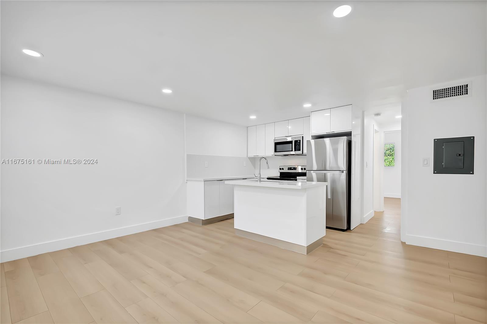 a view of kitchen with stainless steel appliances refrigerator stove microwave and cabinets