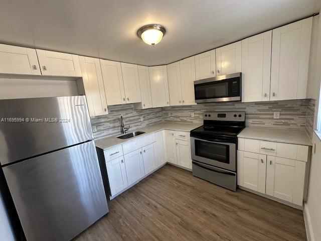 a kitchen with a sink a microwave a refrigerator and cabinets