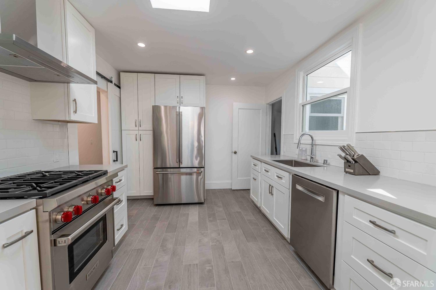 a kitchen with stainless steel appliances granite countertop a sink stove and refrigerator