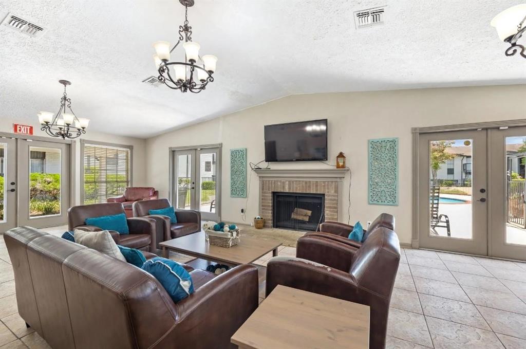 a living room with furniture a chandelier and a fireplace