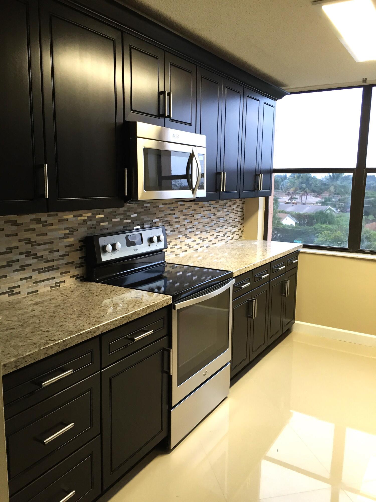 a kitchen with stainless steel appliances granite countertop wooden cabinets counter top space and a sink