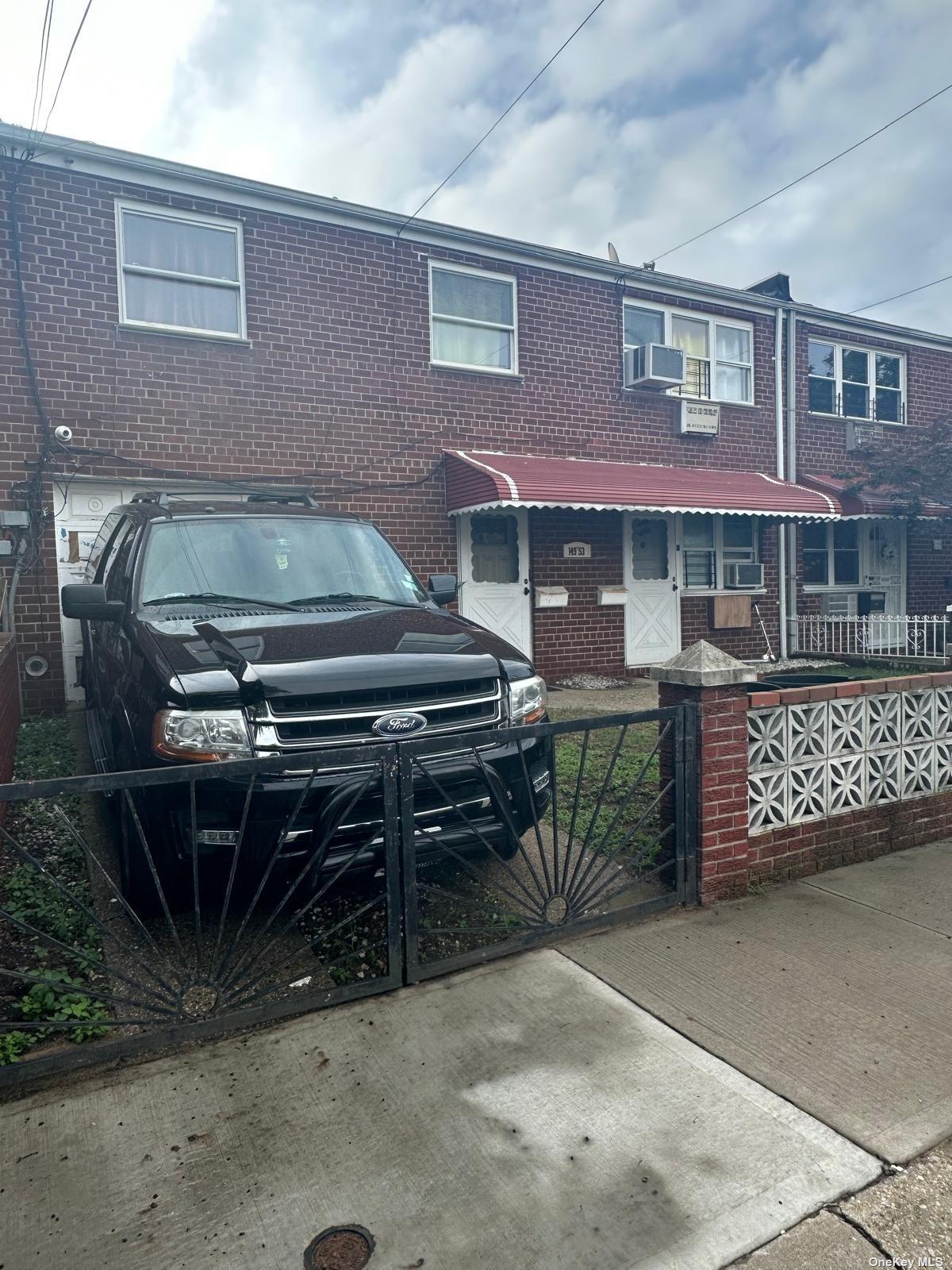 a front view of a house with a parking space