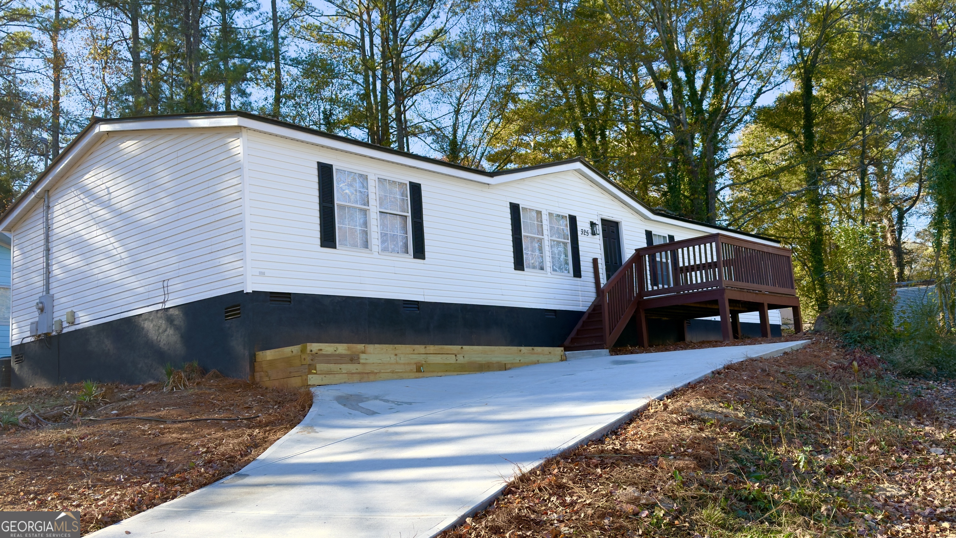 a view of backyard with a deck and a large tree