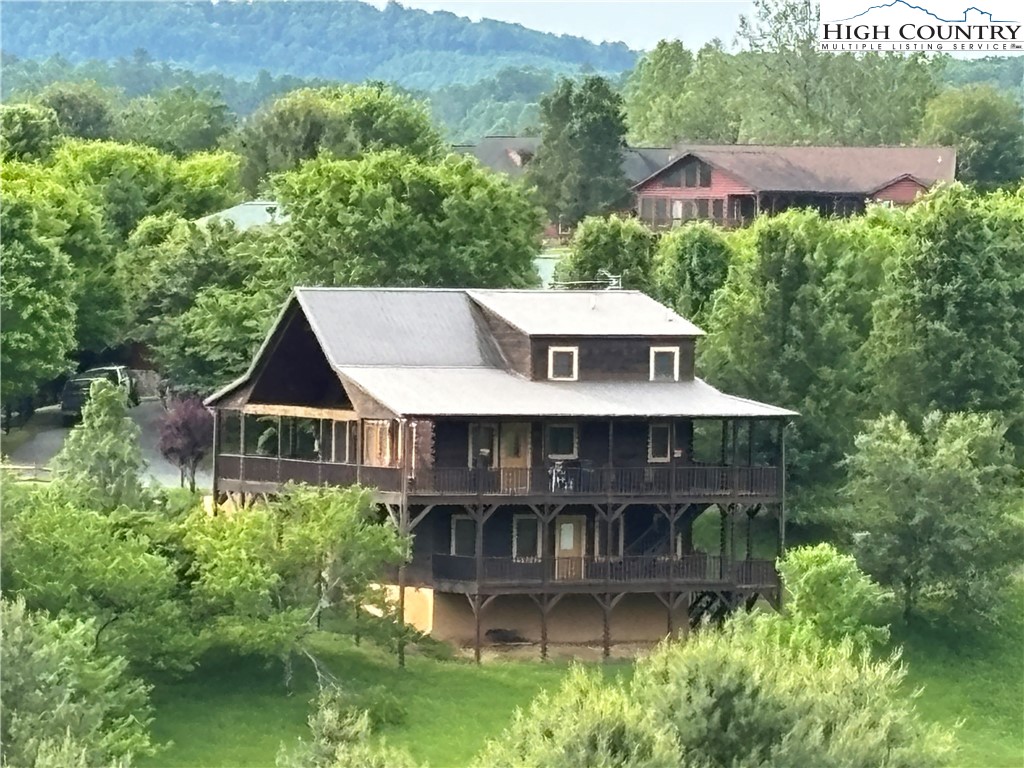 an aerial view of a house with balcony and trees in the background