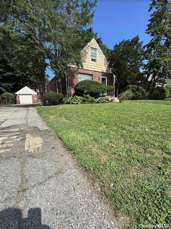 a front view of a house with a yard and trees