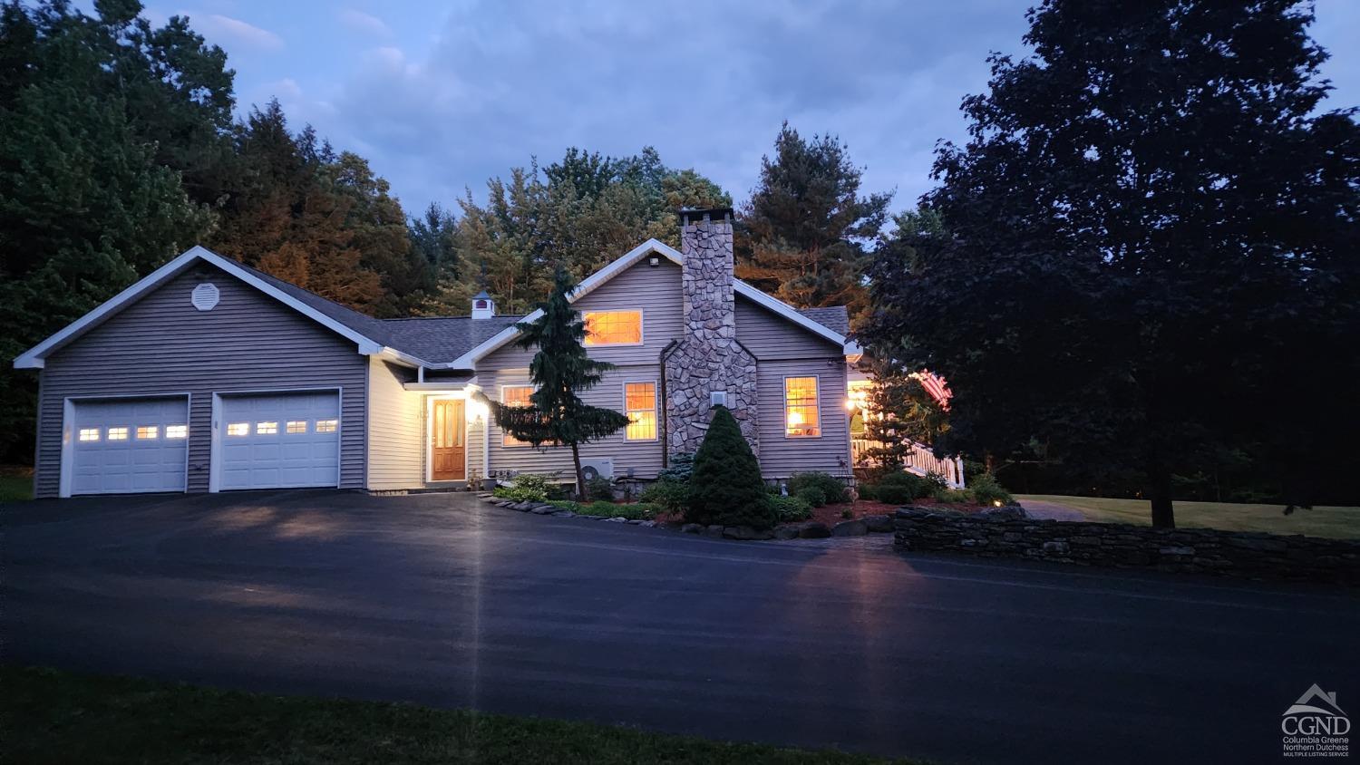 a front view of a house with yard and green space