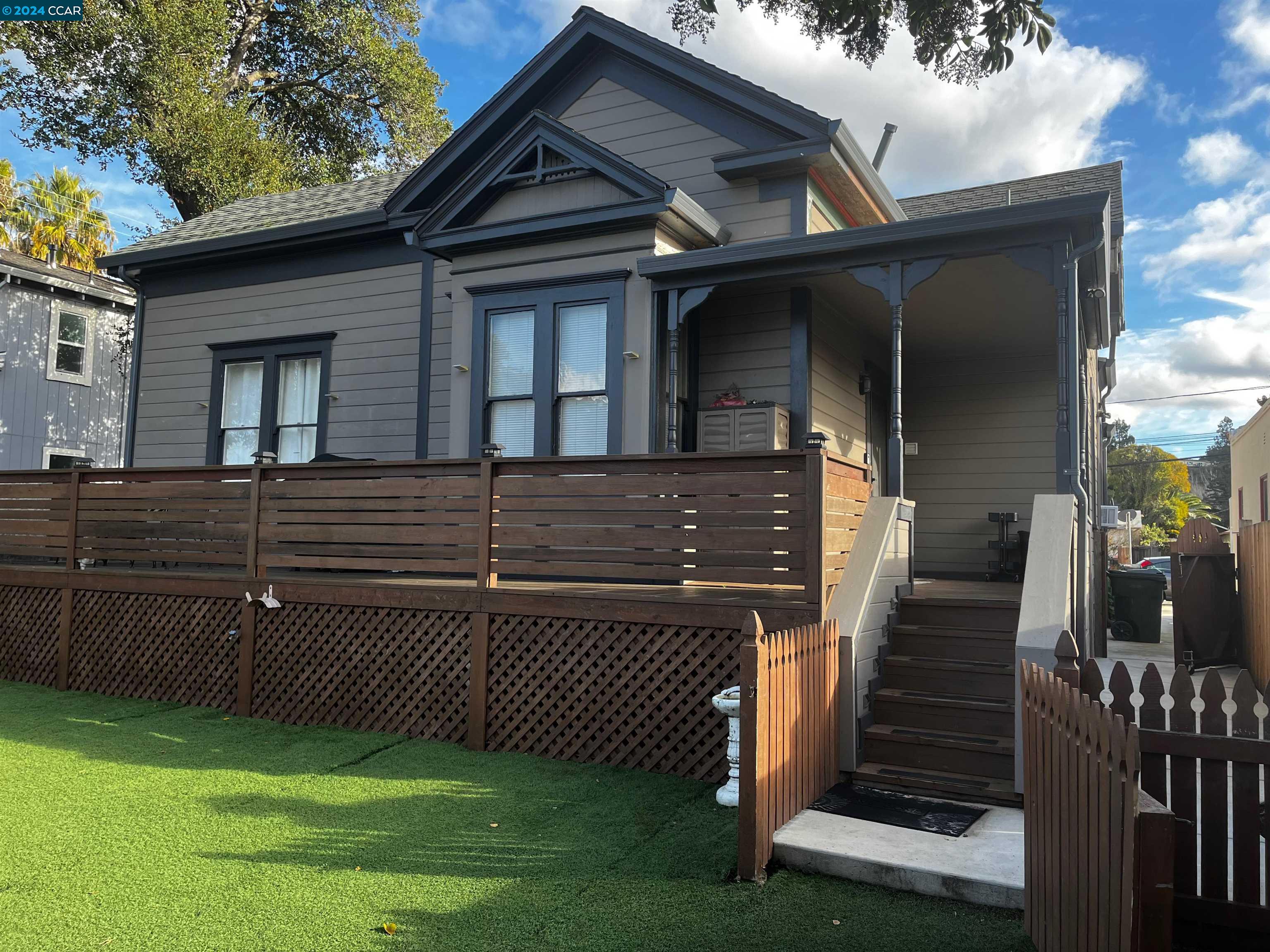 a view of a house with a small yard and wooden fence