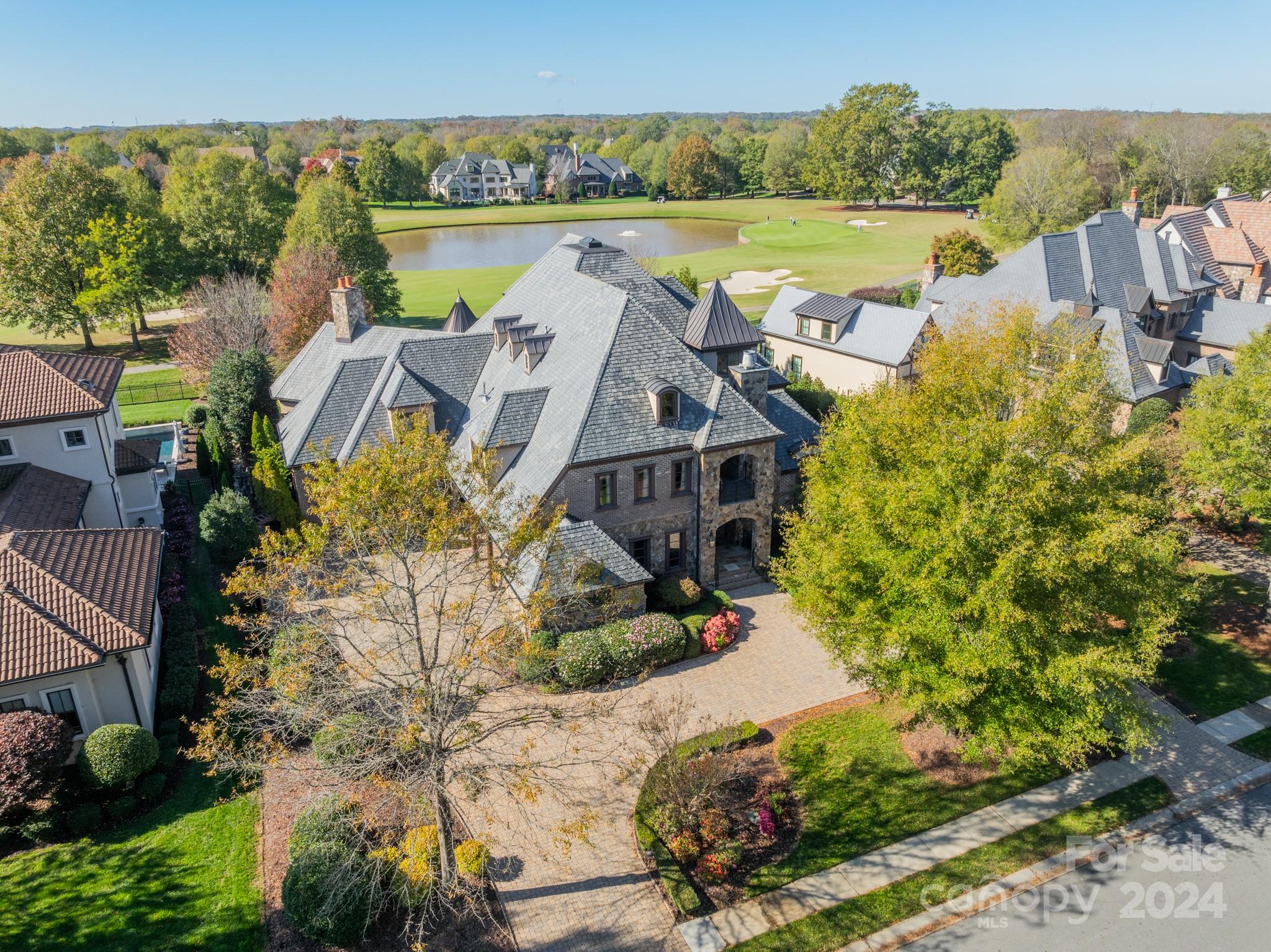 an aerial view of a house with a garden and lake view