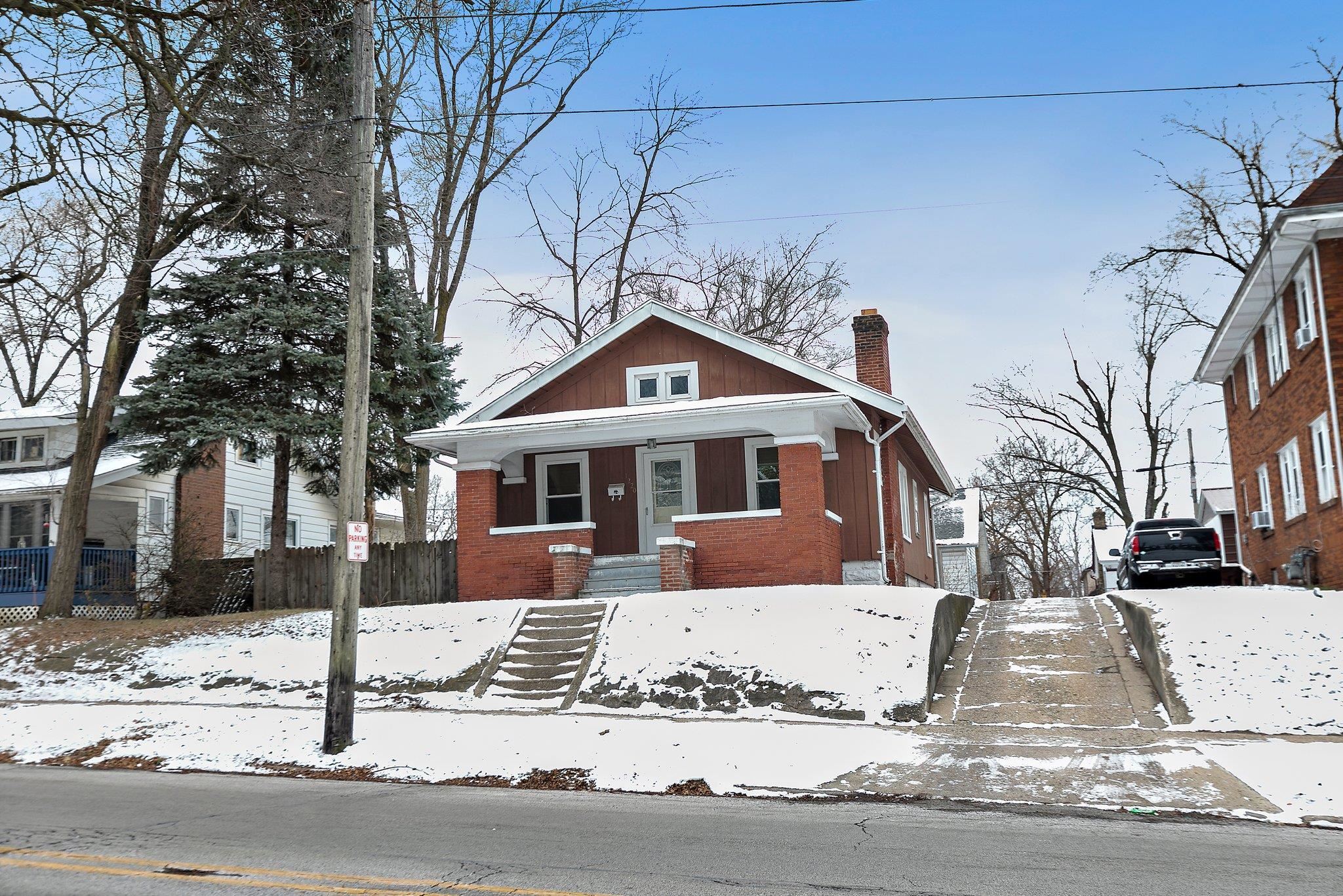 a front view of a house with a yard covered in snow