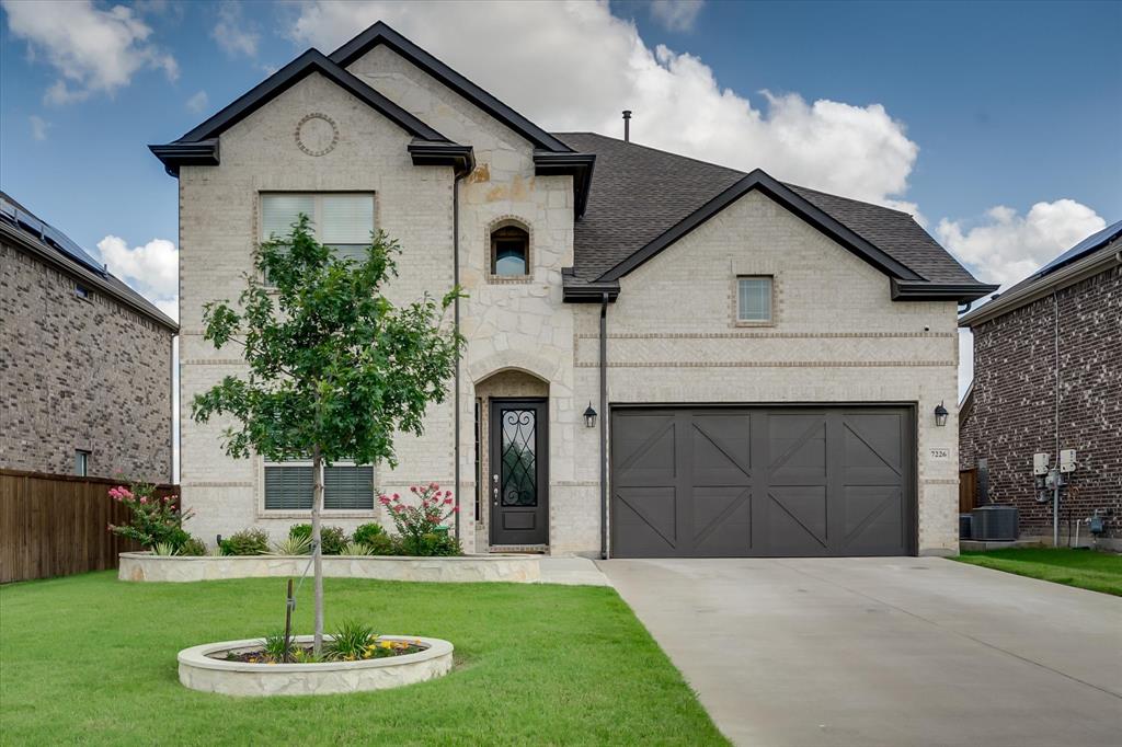 a front view of a house with a yard and garage