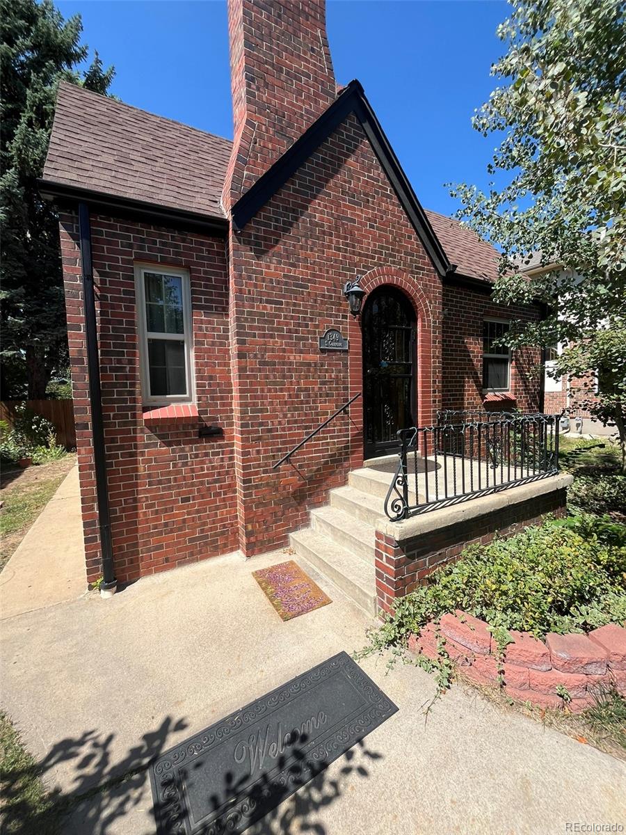 a view of a brick house with wooden fence