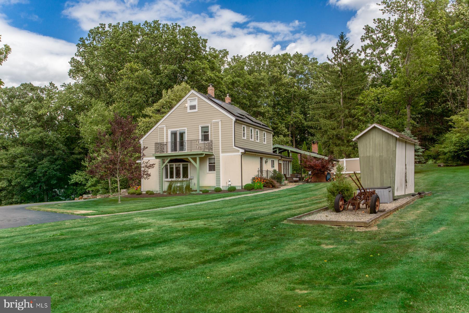 a front view of a house with a garden and trees