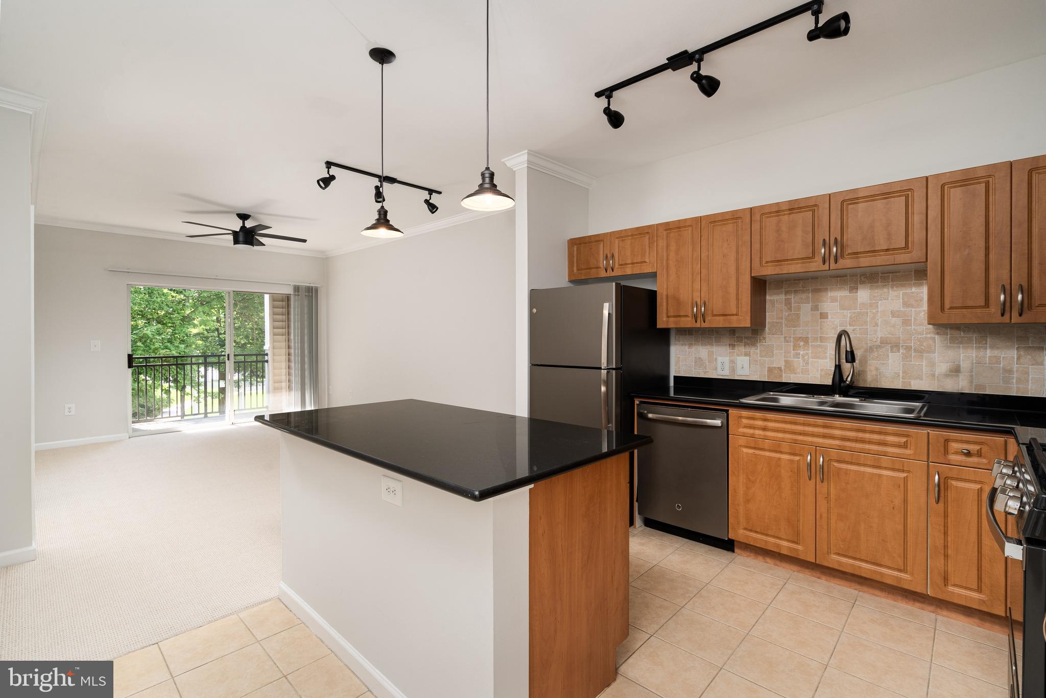 a kitchen with kitchen island a counter top space appliances and a window