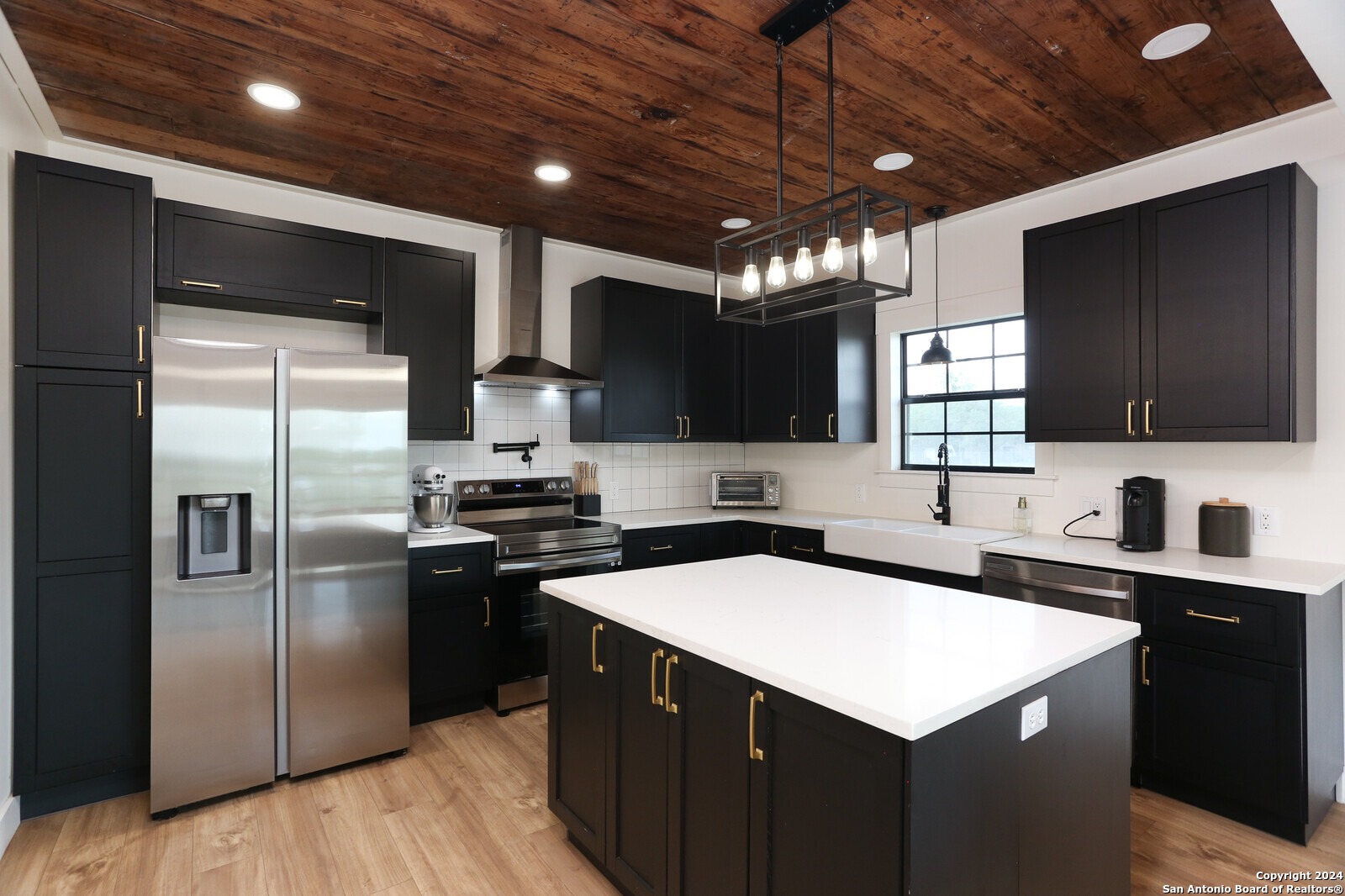 a kitchen with stainless steel appliances a sink a stove a refrigerator cabinets and a counter top space