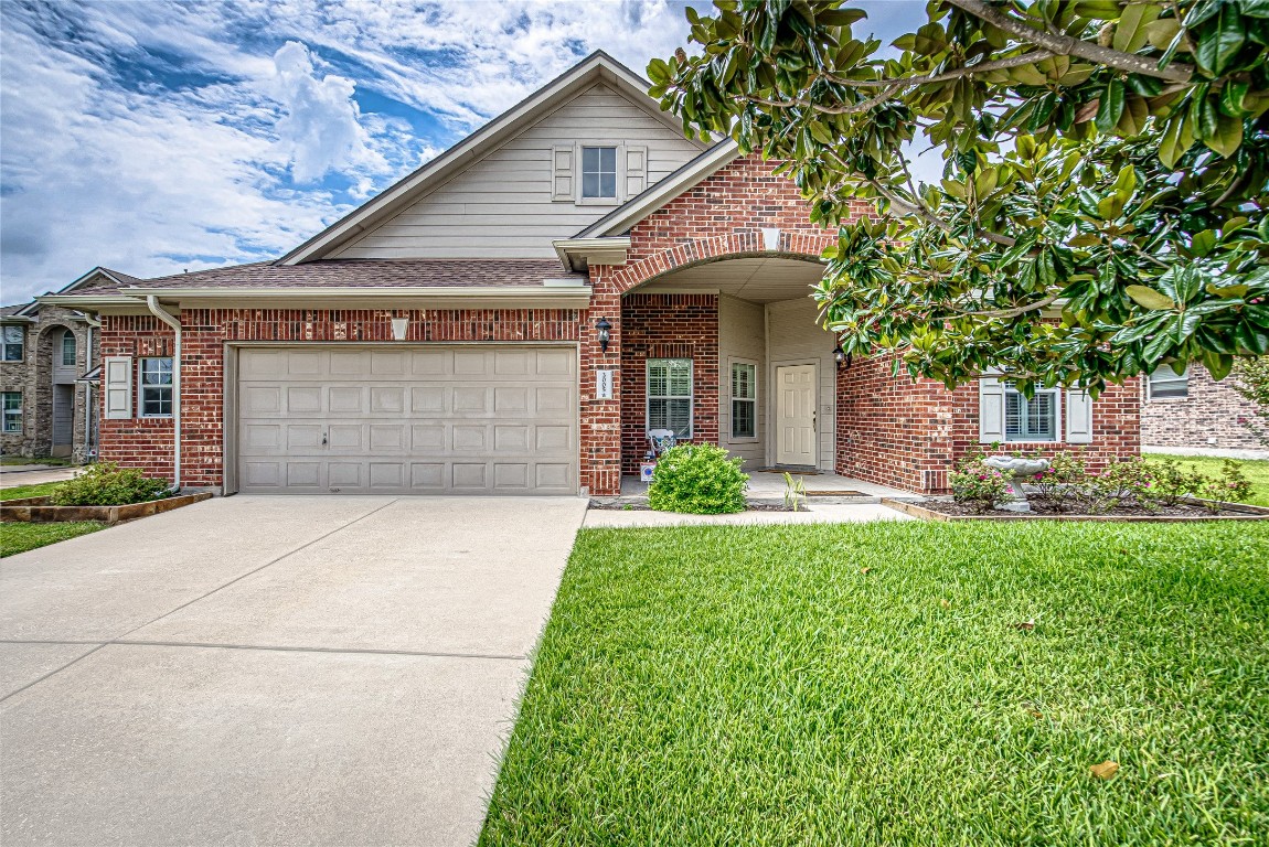 a front view of a house with a garden and garage